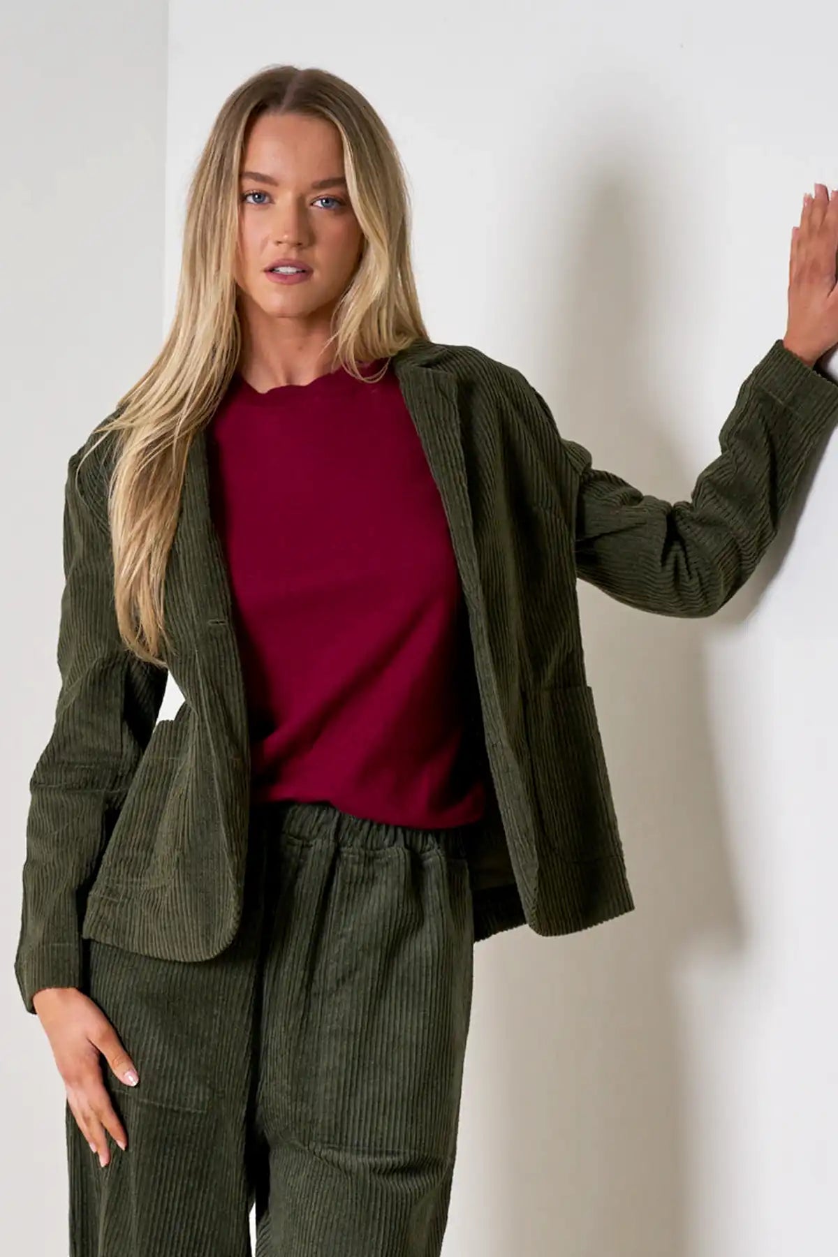 Woman wearing Baltic Corduroy Jacket in Forest front with a red top against a white background