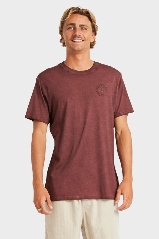 Man wearing a maroon t-shirt with a logo on a white background