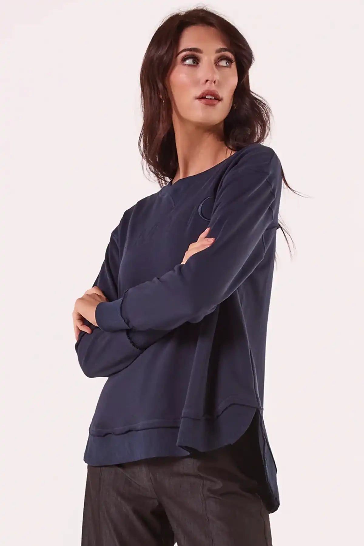 Woman wearing a Chille Everyday Wander Pullover in Navy against a white background side view