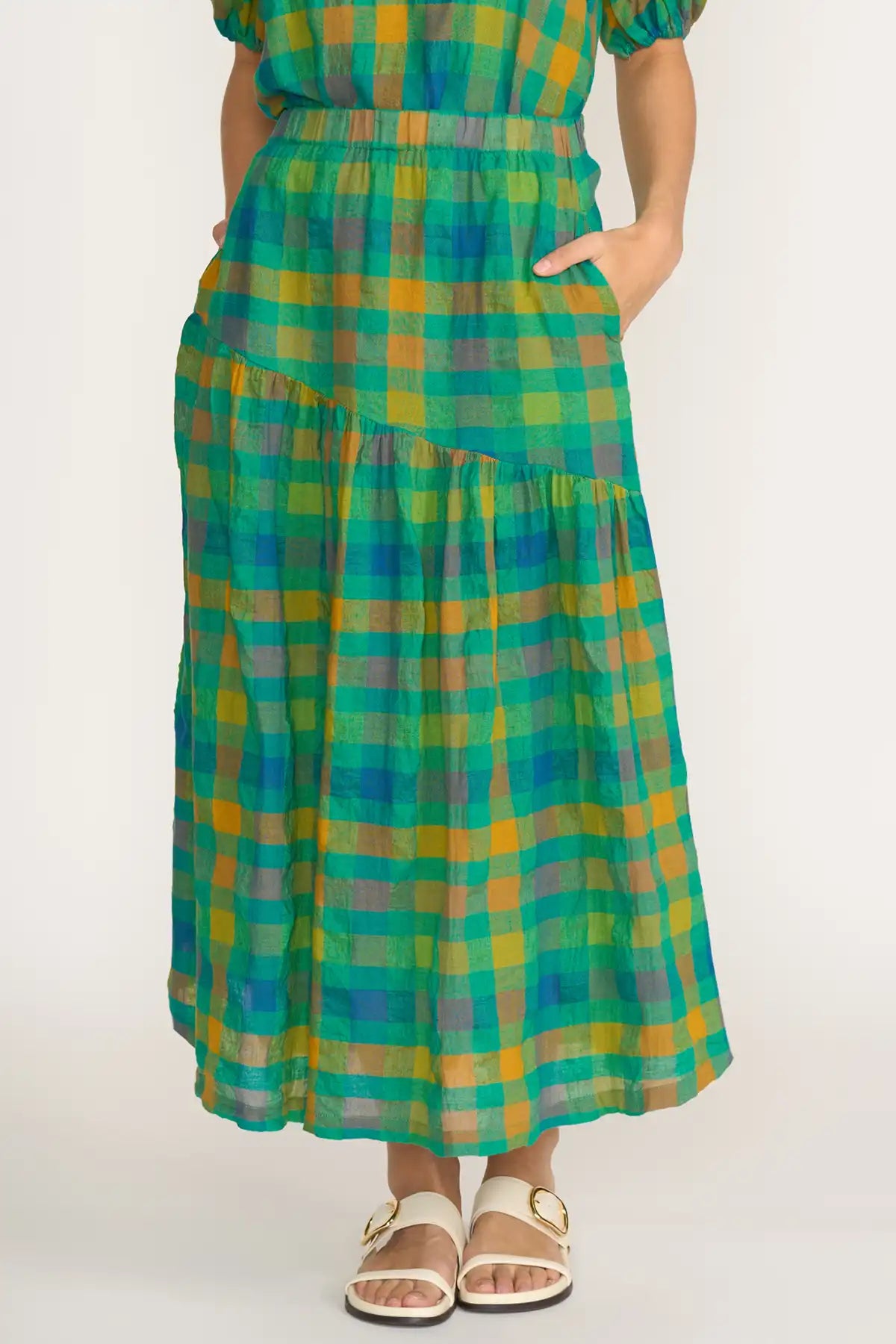 Person wearing a  Foil Checkmate Cotton Linen Skirt in Greencheck on a white background detailed front view showing pockets