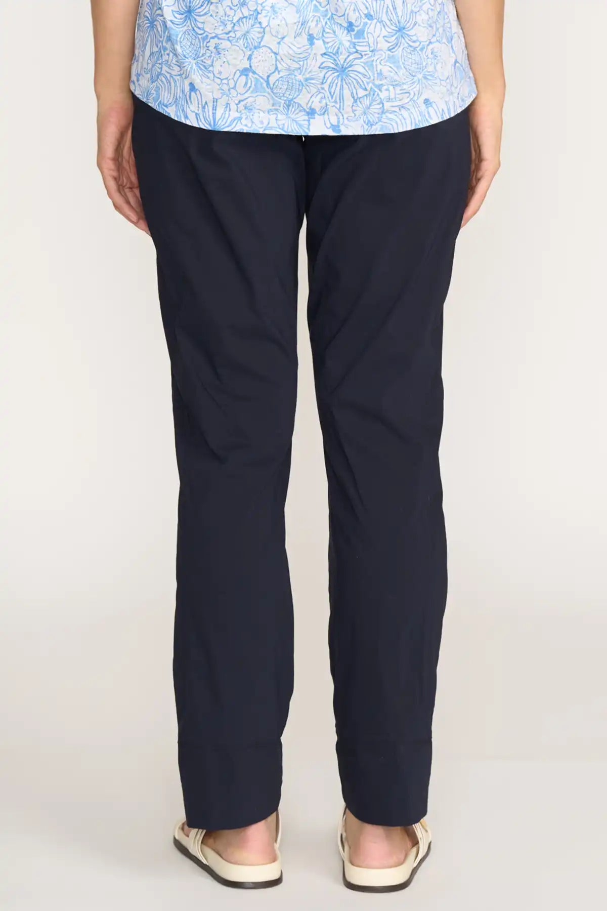 Person wearing Foil Gemini Pant in True Navy and a light blue floral top on a white background back view