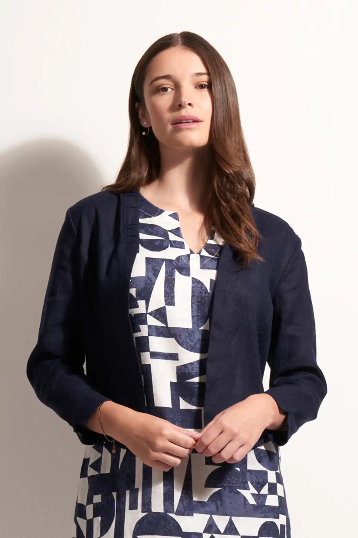 Woman wearing a Foil Linen Gather Together Jacket in True Navy over a geometric-patterned dress on a white background front detailed view