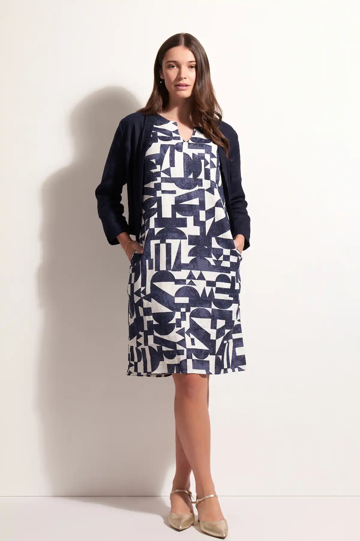 Woman wearing a patterned dress with a  Foil Linen Gather Together Jacket in True Navy a white background