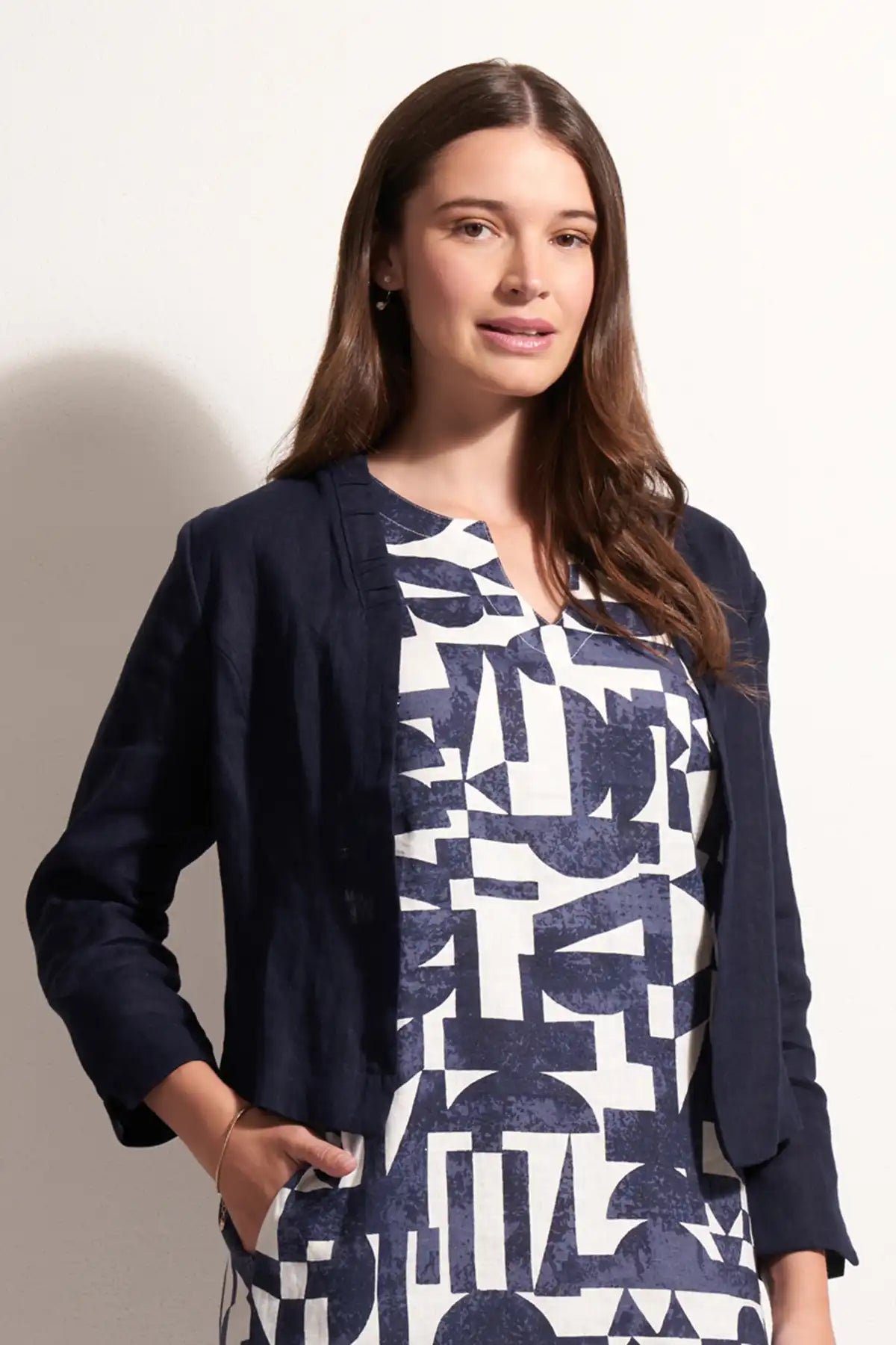 Woman wearing a Foil Linen Gather Together Jacket in True Navy over a patterned dress on a plain background front view with jacket open