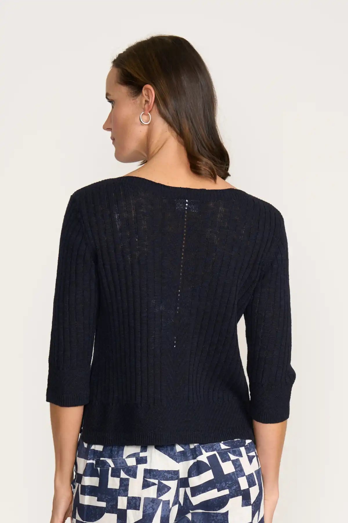 Woman wearing a Foil Nitty Gritty Sweater in True Navy with a white background back view