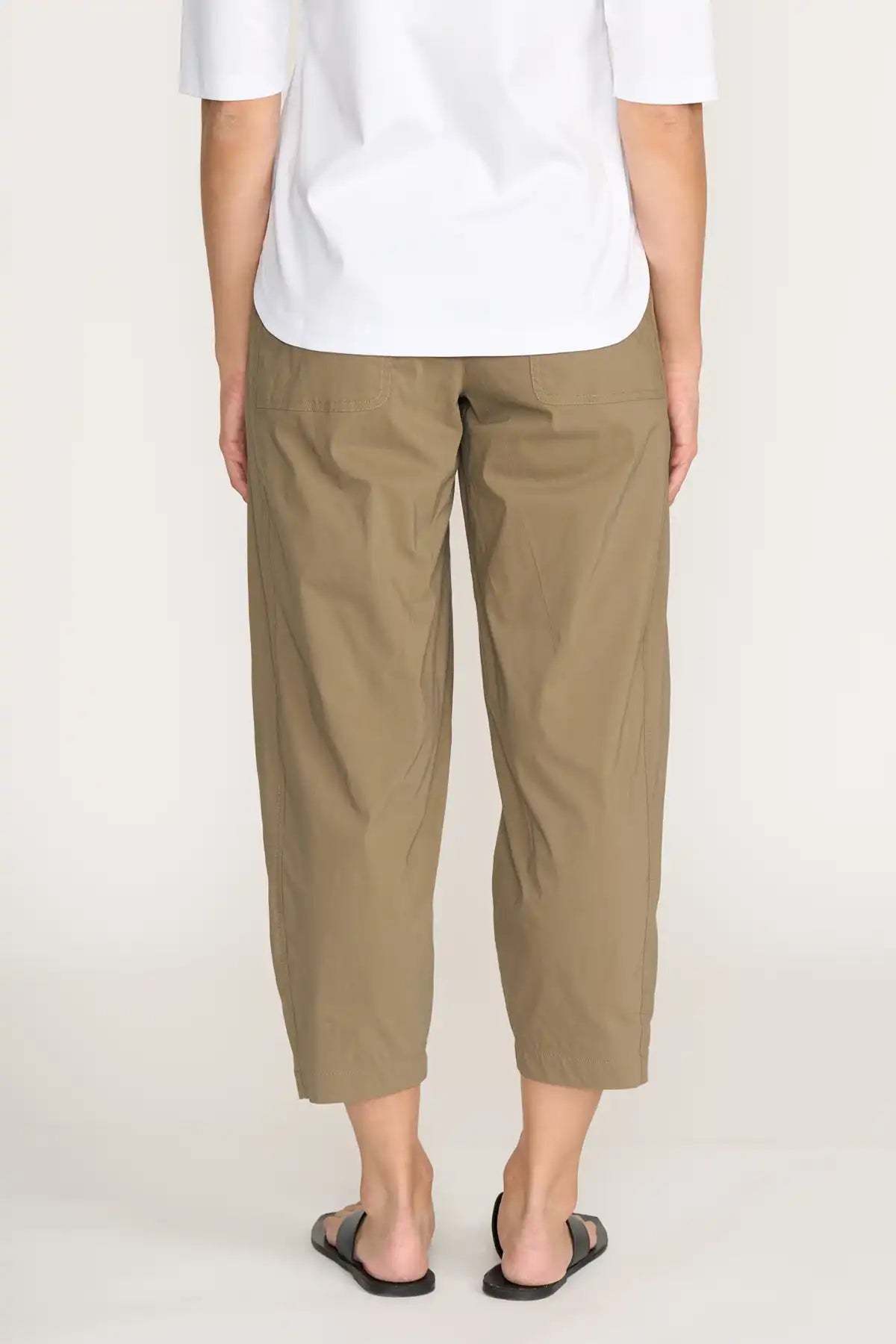 Person wearing Foil Pump it Up Pant in Dune and a white shirt on a plain background back view