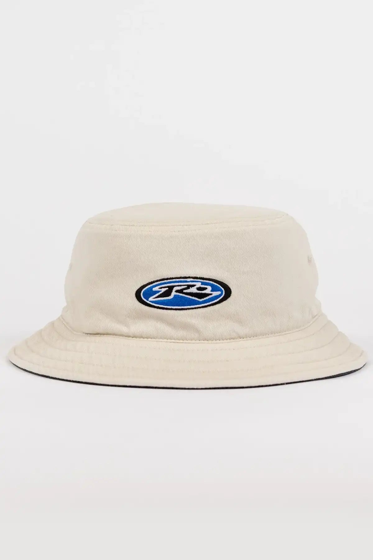 Rusty Kick Flip Reversible Bucket Hat in Oatmeal with a blue and black logo on a white background
