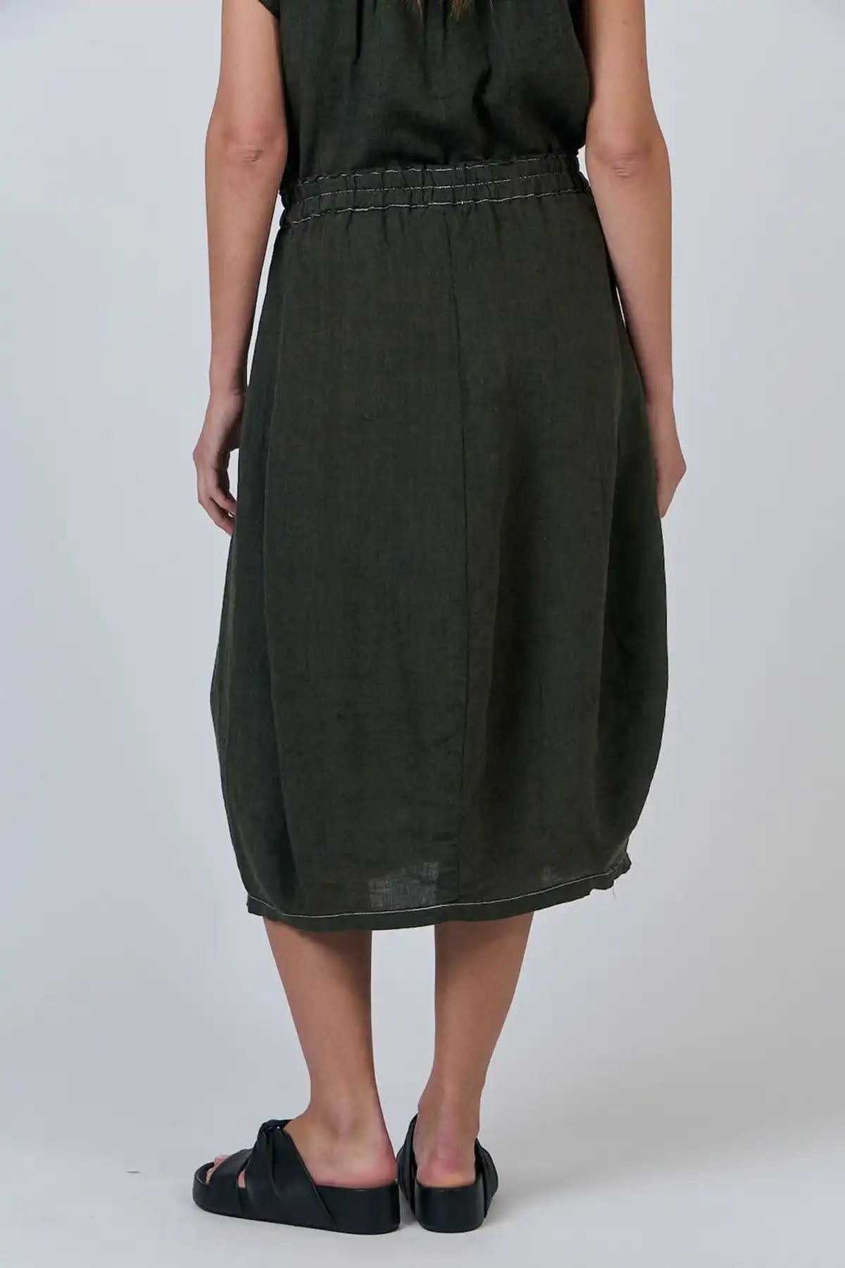 Person wearing a  Licorice Linen Skirt on a white background