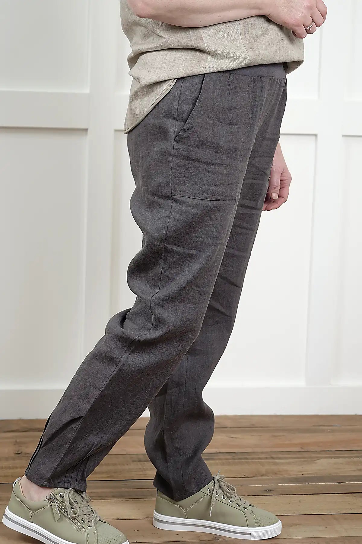 Person wearing Lina Linen Pull-On Pants in Charcoal from the side and beige shoes in a minimal indoor setting