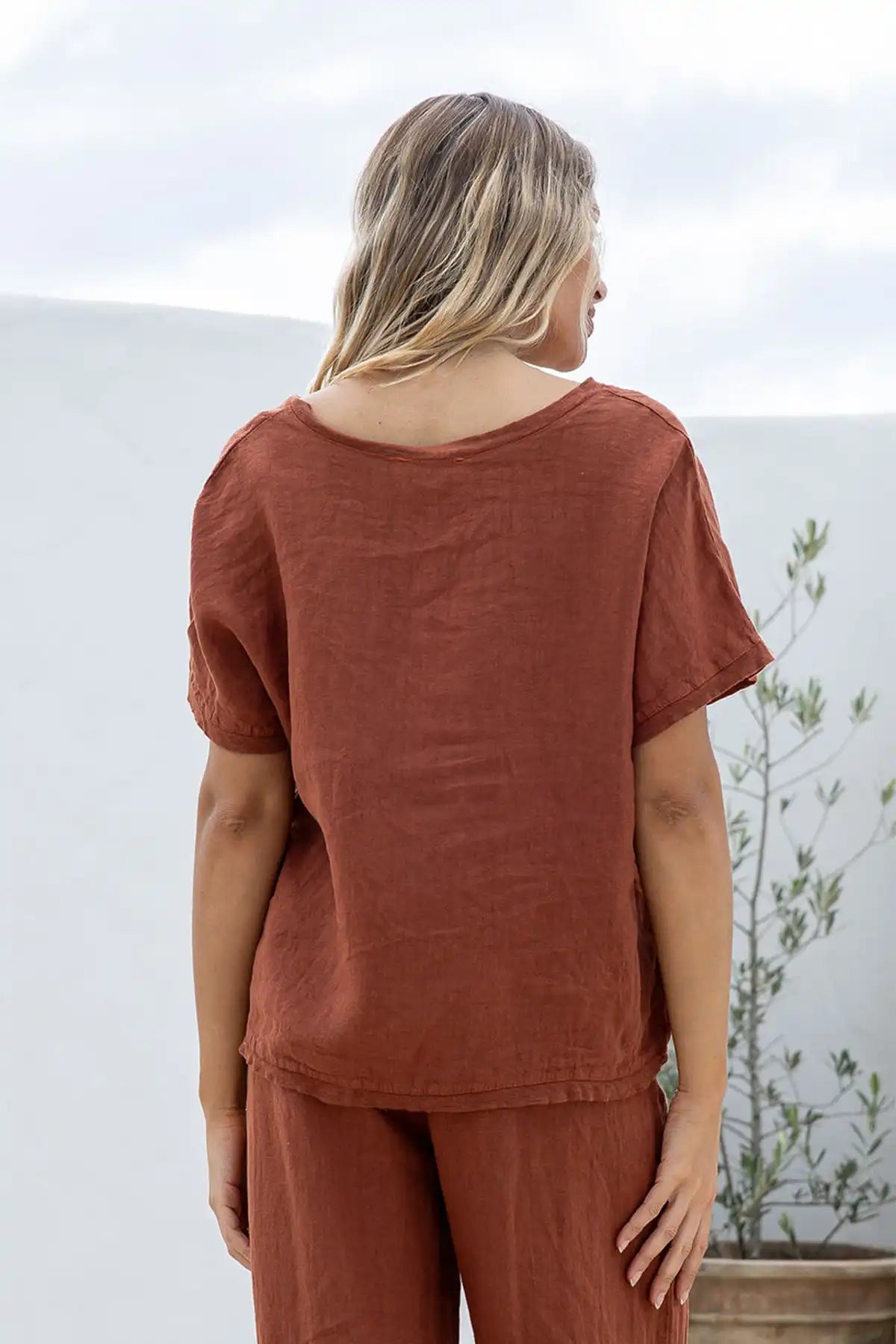 Person wearing aLucia Italian Linen Coco Top and pant viewed from behind with a plain background