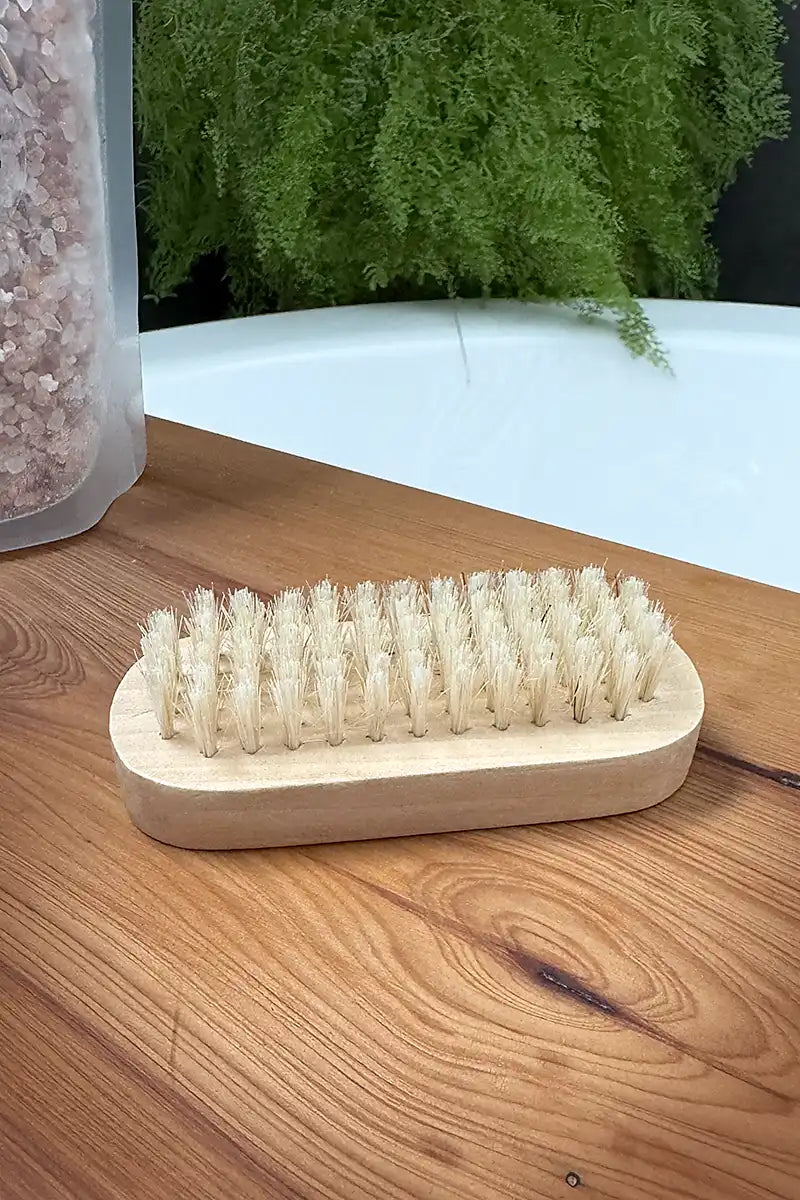 Natural Wooden Nail Brush on bath board showing bristles facing up