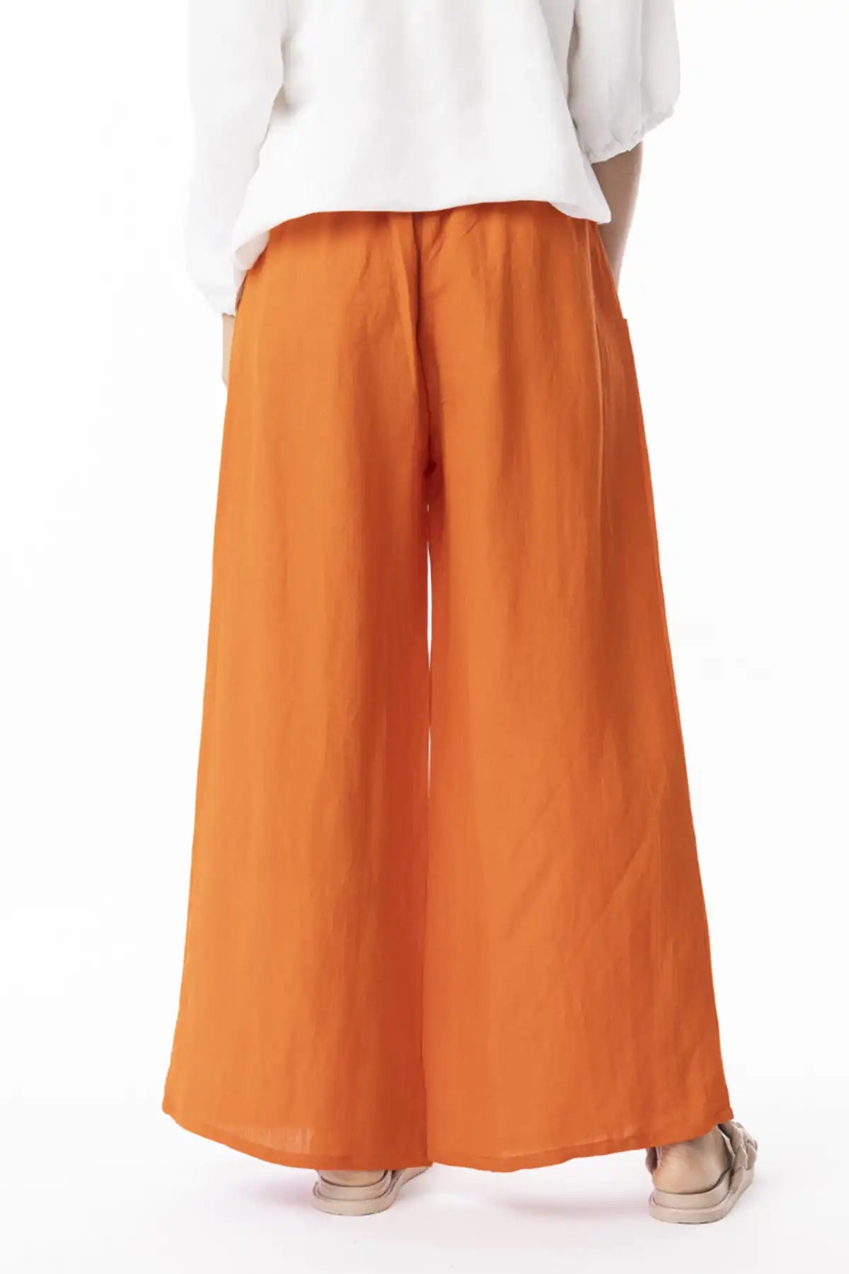 Orientique Escape Linen Wide Leg Pants in Mandarin worn with a white top on a white background