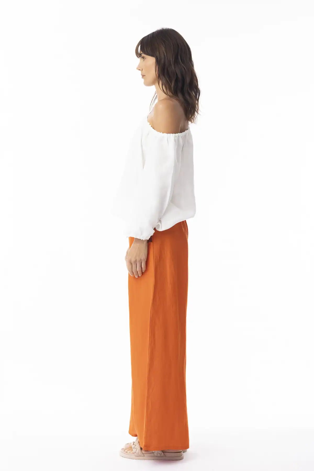 Woman wearing a white top and Orientique Escape Linen Wide Leg Pants in Mandarin on a white background