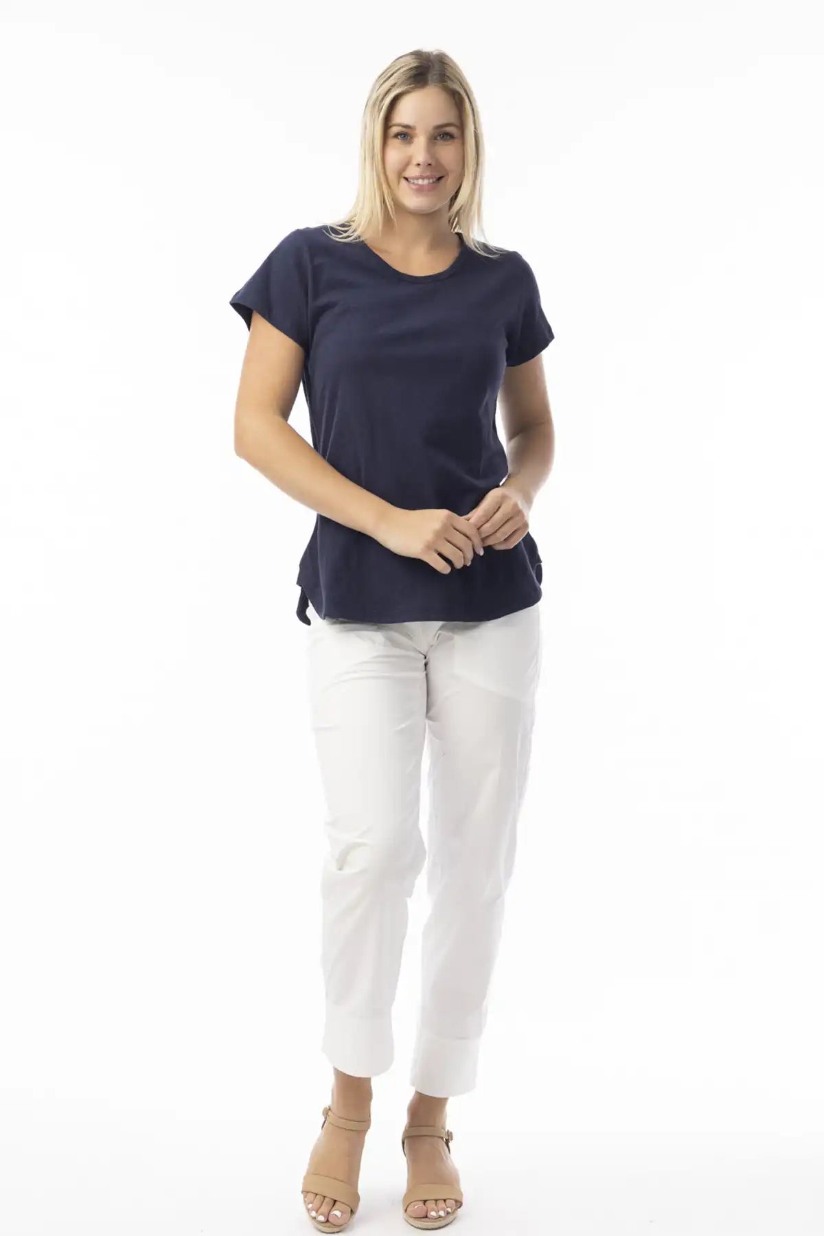 Woman wearing a Orientique Essentials Organic Cotton Crew Tee in Navy and white pants on a white background