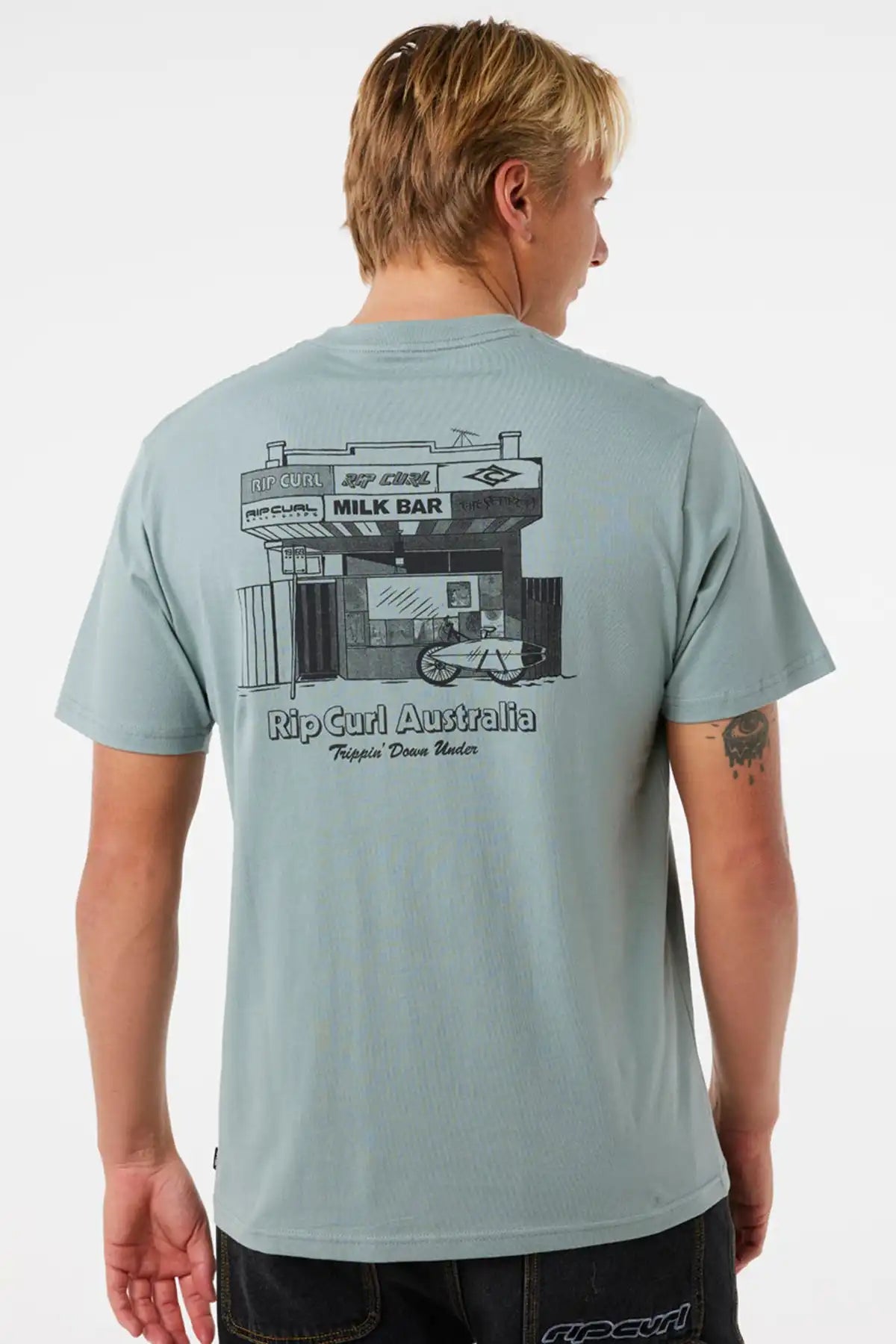 Person wearing a light blue t-shirt with a graphic design on the back, standing against a plain background.