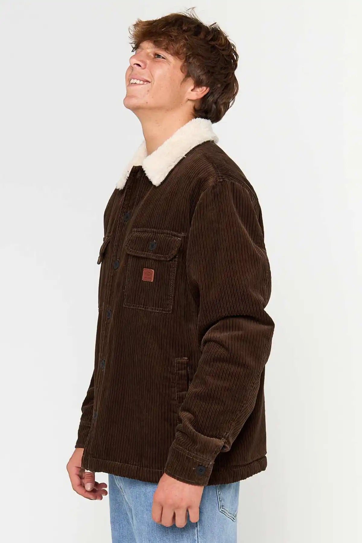 Person wearing Rip Curl Men's Bells Sherpa Jacket in Coffee with white fur lining on a white background side view