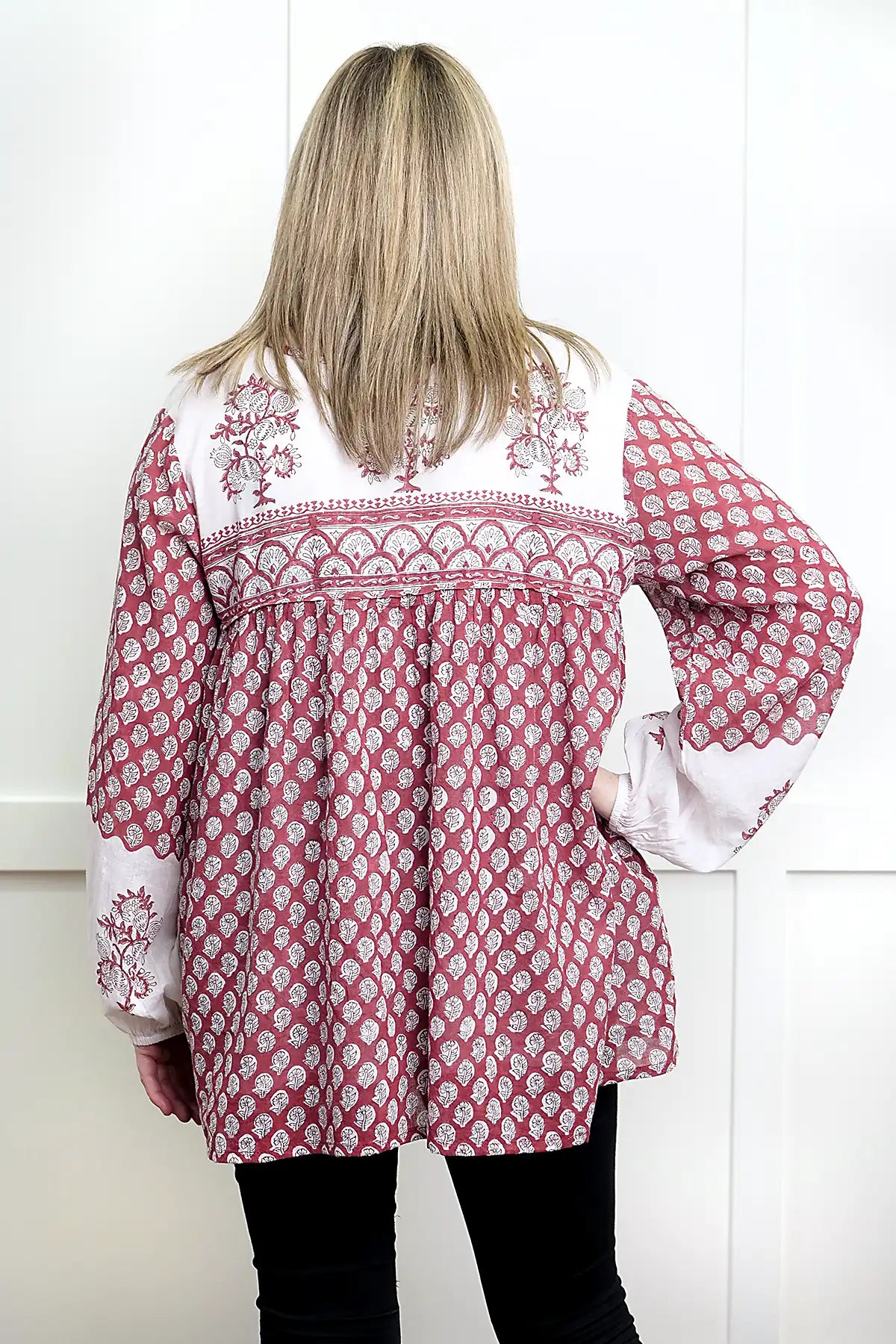 Person wearing a red and white patterned Seaberry Gypsy Top with a white background - back view