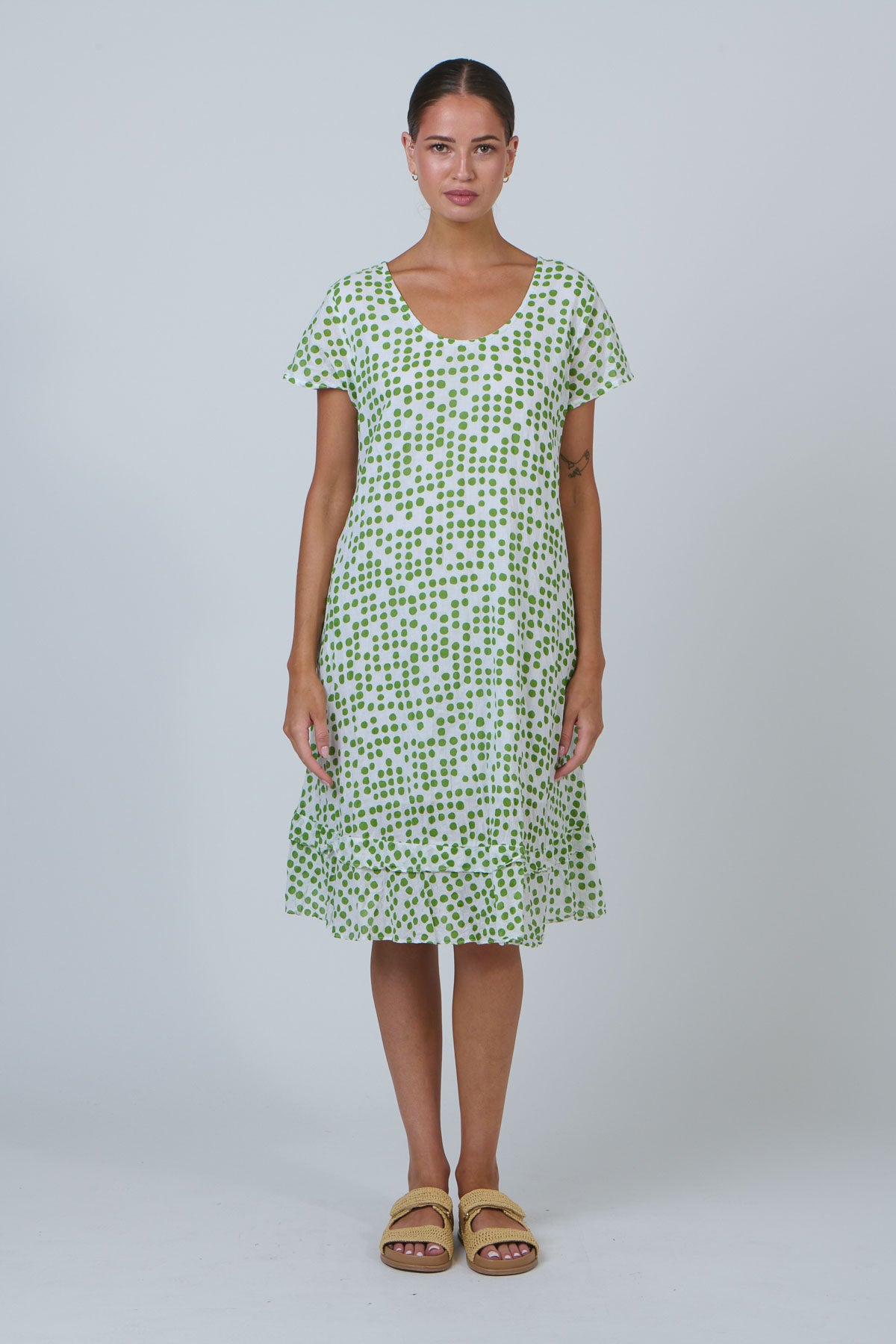 Woman wearing a green patterned dress on a white background