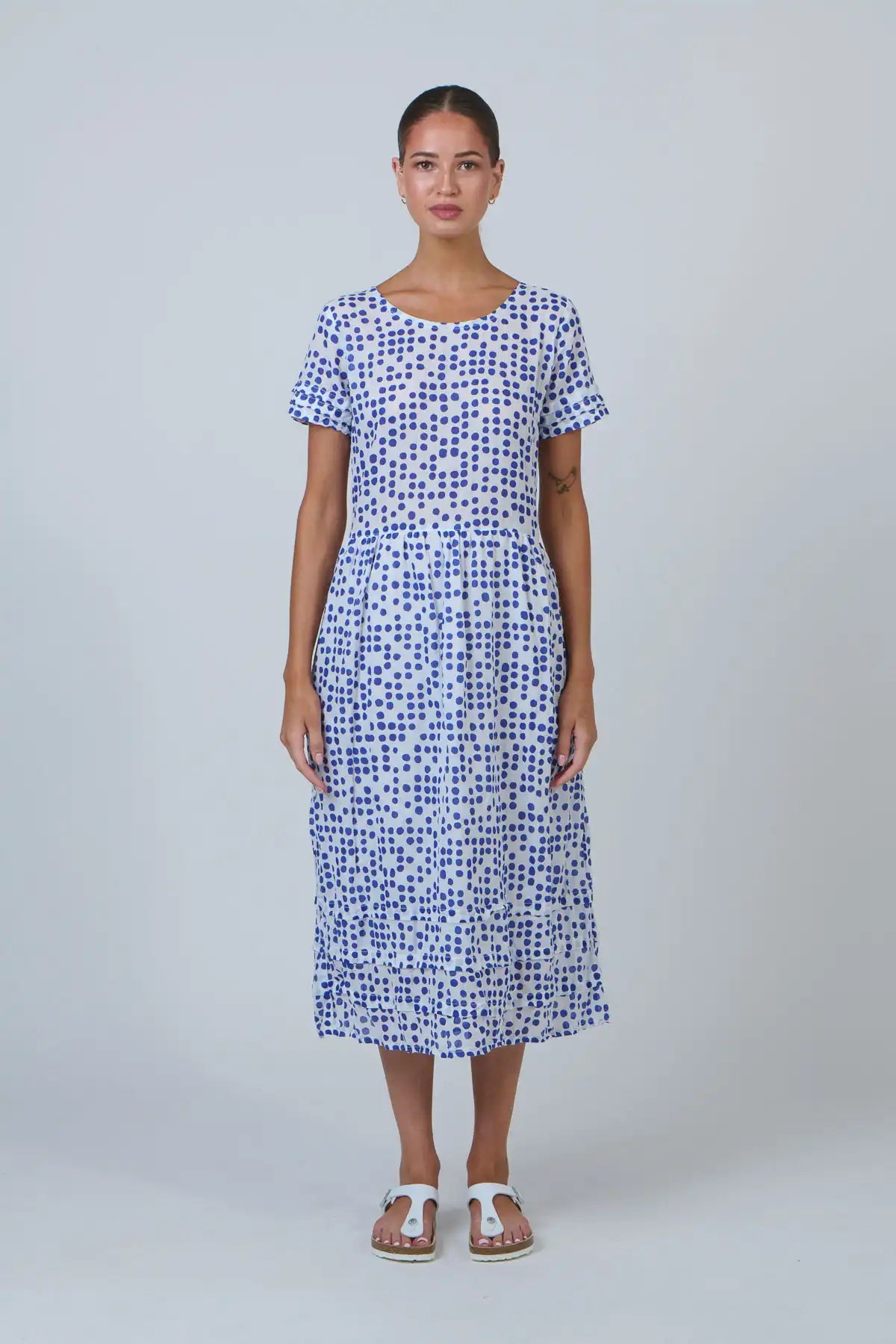 woman wearing a white dress with blue dot print front view on white background