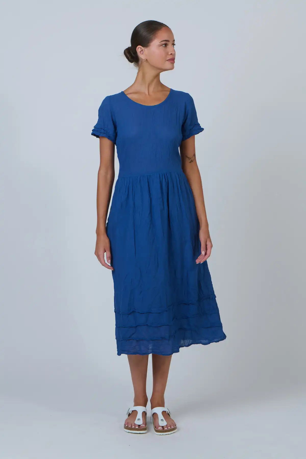 Woman wearing a blue dress against a plain background