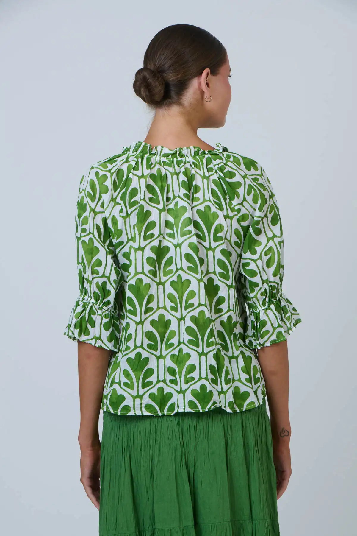 back on view of woman wearing the Summer Garden Crinkle Cotton Top and green skirt