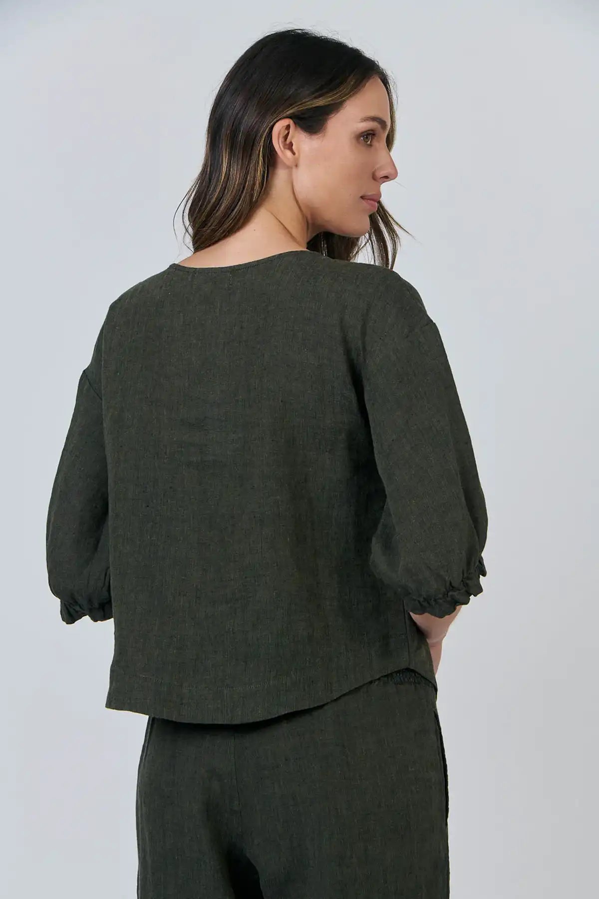 Woman wearing a green outfit against a white background
