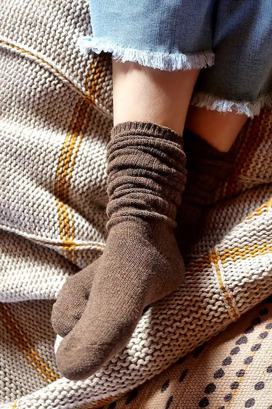 model relaxing on coach wearing Chille Wool Blend Socks in Chocolate Brown