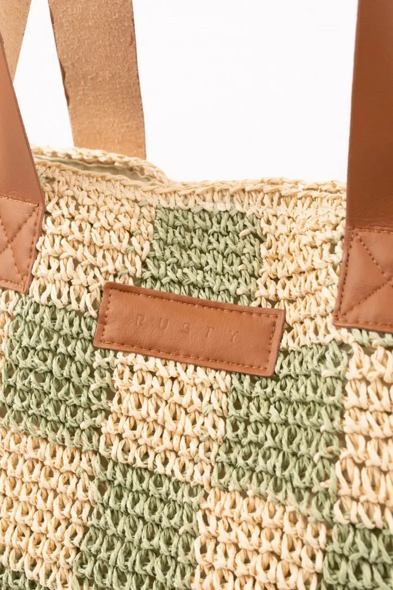 detail view of logo badging on the Rusty Checkmate Straw Beach Bag in Mint