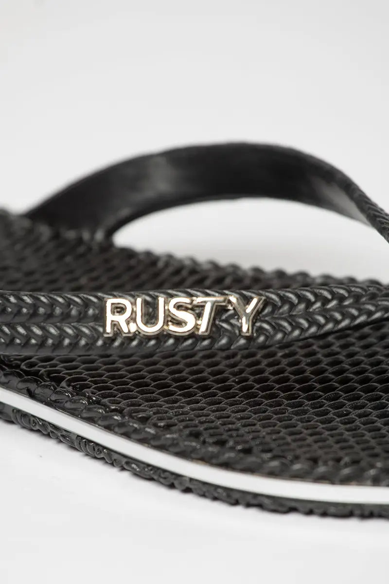 logo detail view of the Rusty Womens Flippin Tong in Black