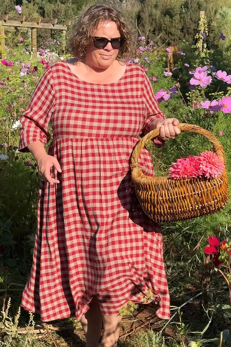 Red Gingham Dress with model walking through the flower garden