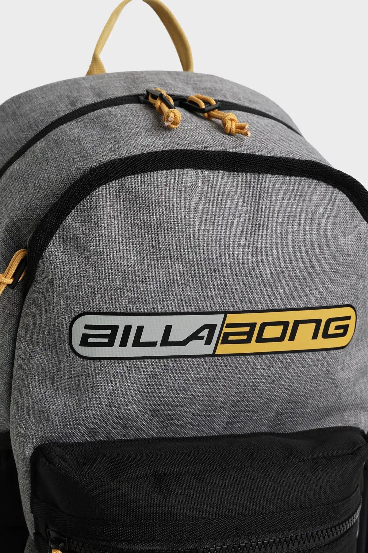 Gray Scallop Backpack with yellow and black Billabong logo on a light gray background