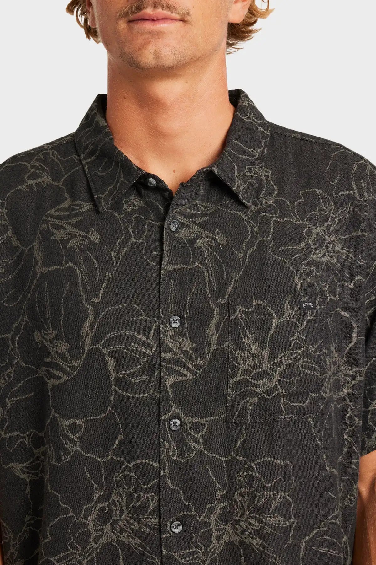 Man wearing a Billabong black floral patterned shirt against a white background