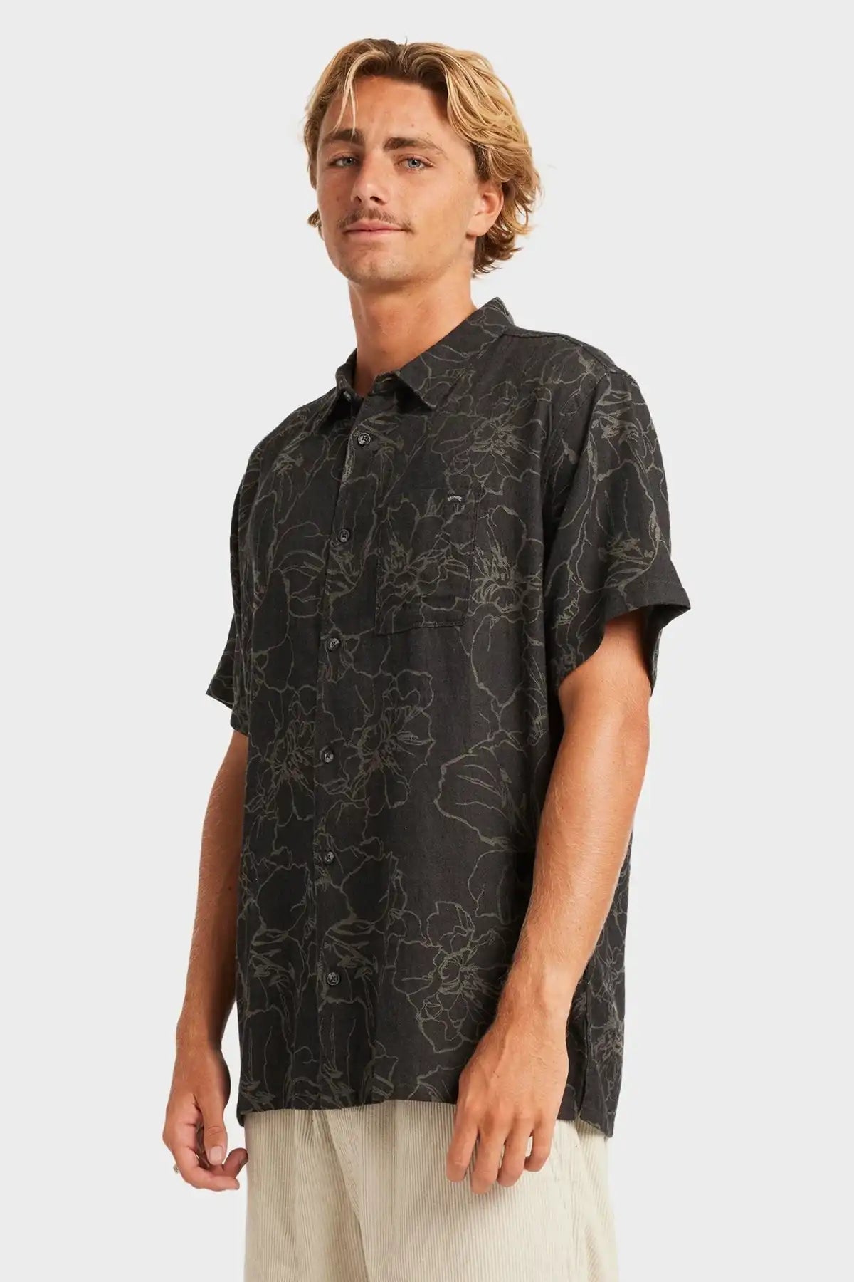 Man wearing a black Billabong patterned shirt on a white background