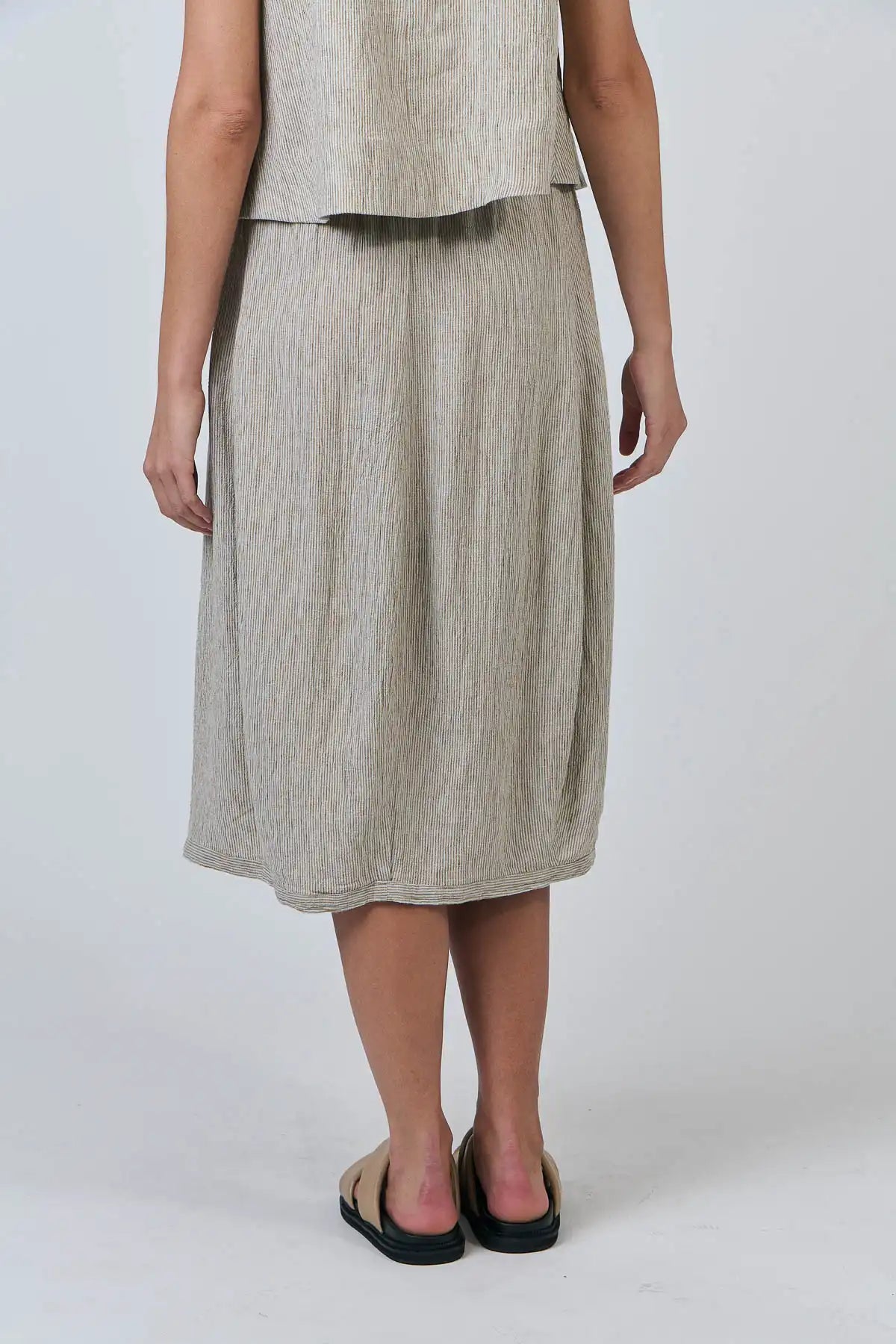Person wearing a beige sleeveless top and Blister Stripe Linen Skirt on a white background rear view showing back of skirt