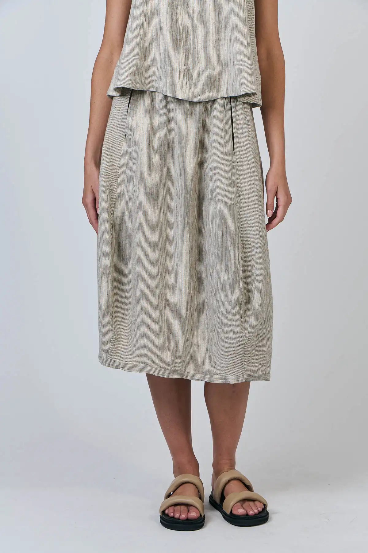 Person wearing a beige Blister Stripe Linen Skirt and top on a white background front view hands by side