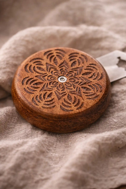 Wooden bread lame with intricate carvings on a textured fabric background
