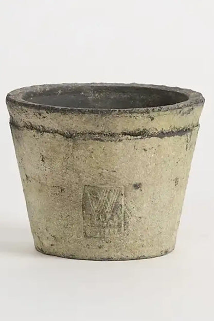 Pottery container with candle and a logo embossed in the side on a white background