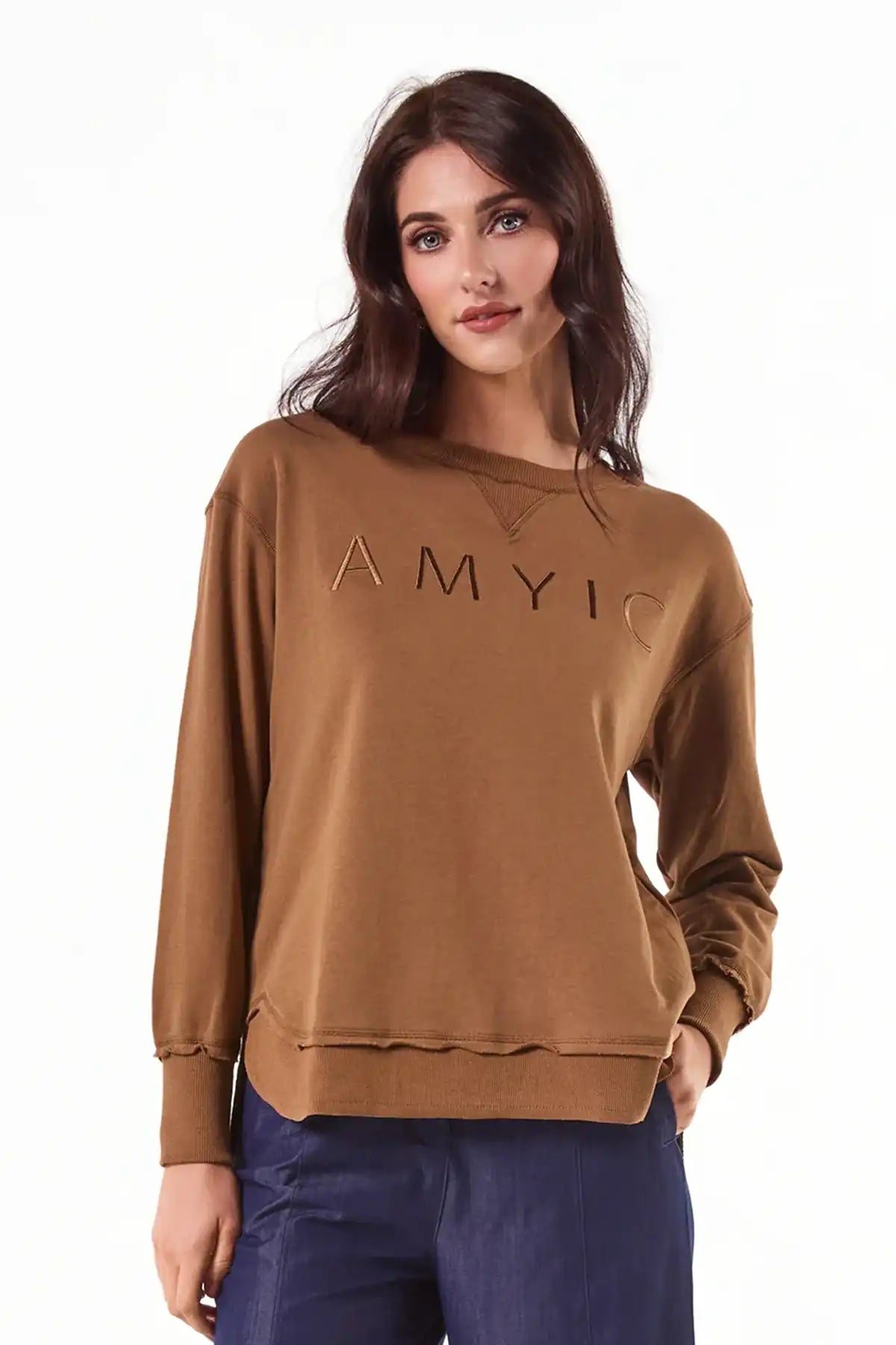 Woman wearing a Chille Everyday Wander Pullover in Mocha with embroidery on front against a white background