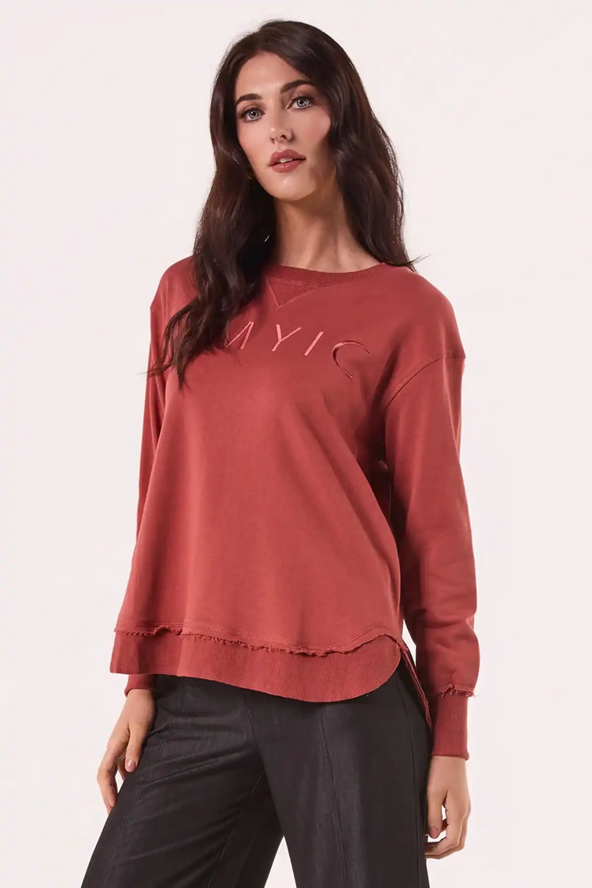 Woman wearing a Chille Everyday Wander Pullover in Rust with embroidery logo on a white background front view