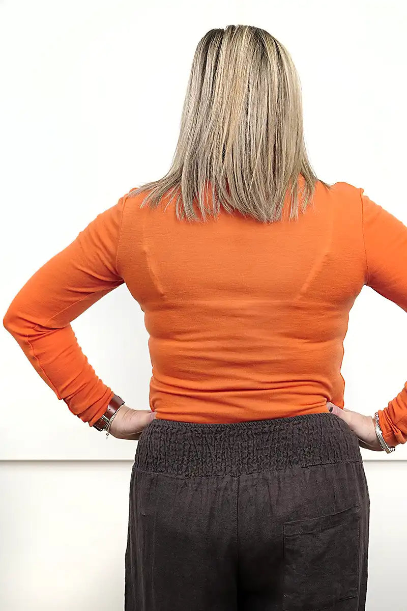 Chille Merino Whisper Top in orange under chocolate sofia pinafore dress back view tucked in