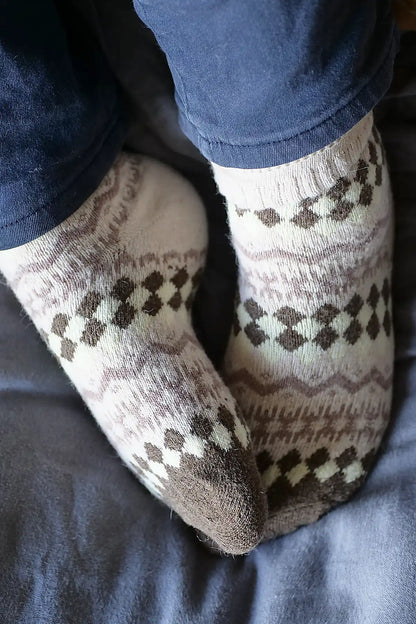 Patterned socks worn on a person's feet with a dark background