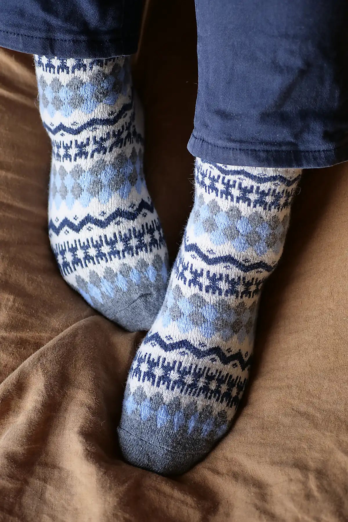 Patterned socks worn on a brown surface