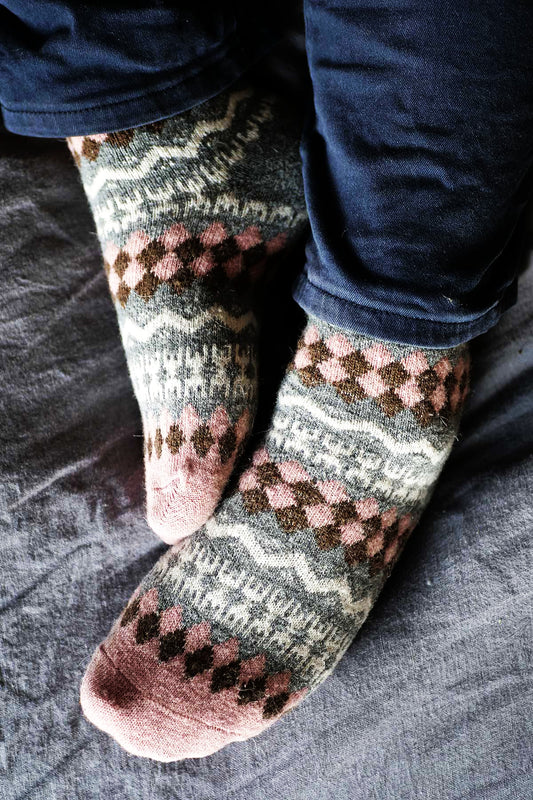 Patterned socks worn by a person on a textured surface