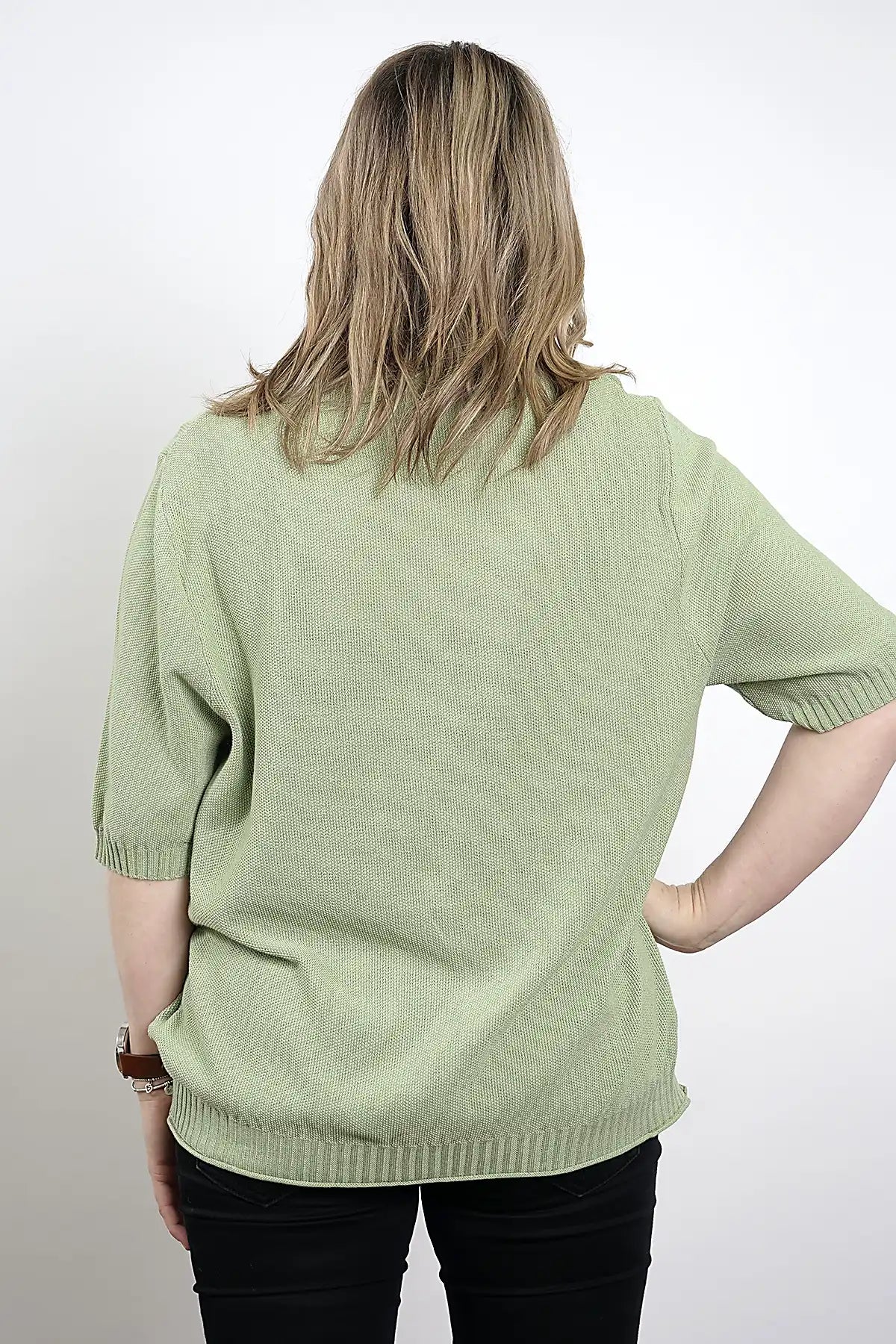 Person wearing a Coastal Ease Cotton Knit Tee in Sage Green with short sleeves on a white background back view