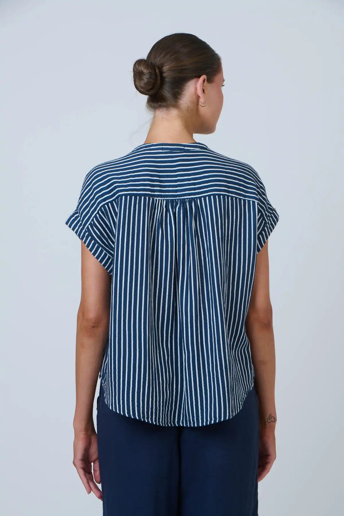 back view of lady wearing the coastal strip cotton top in navy and white