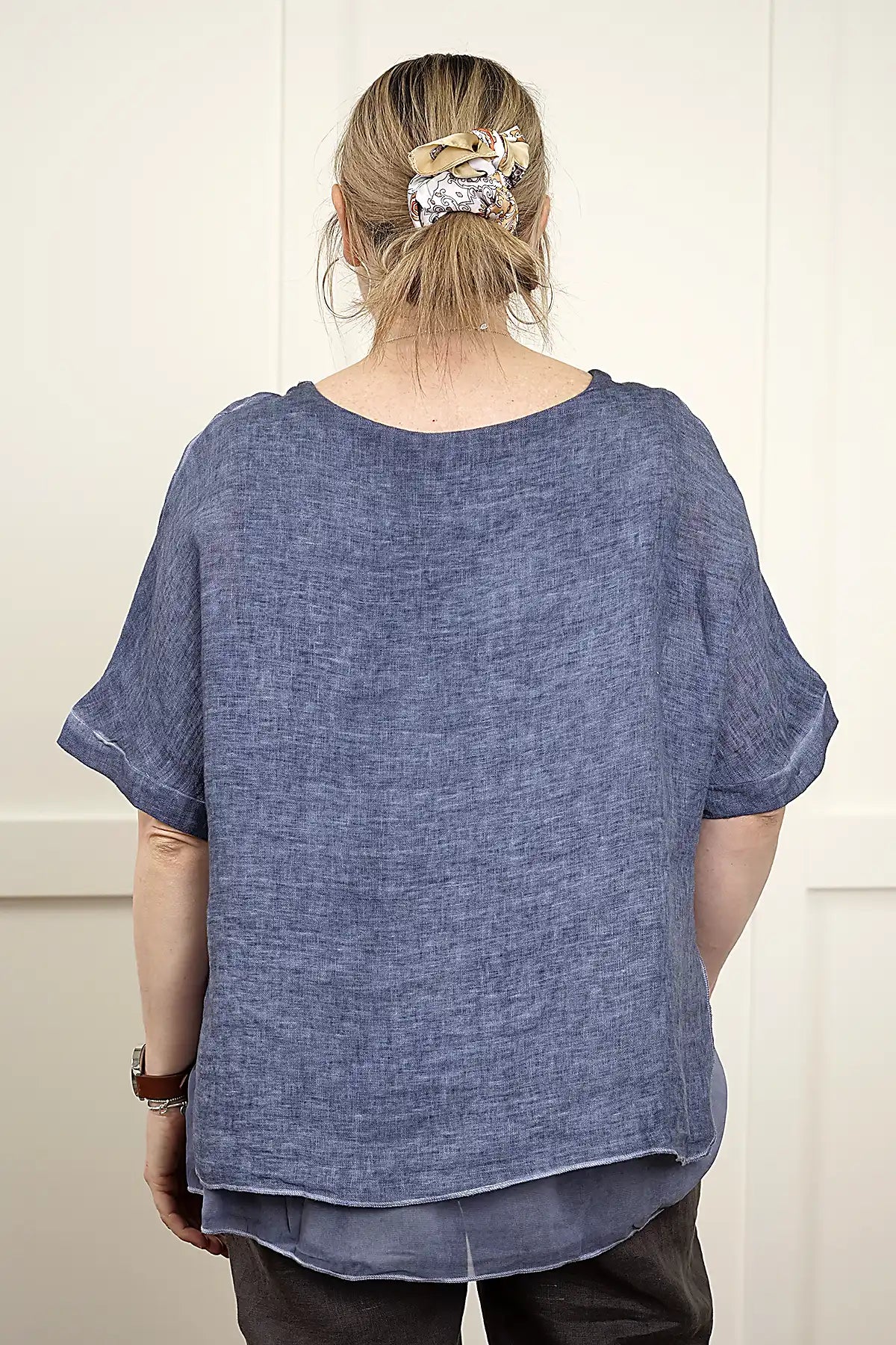 Person wearing a Elena Linen Top in Denim from behind with a plain background