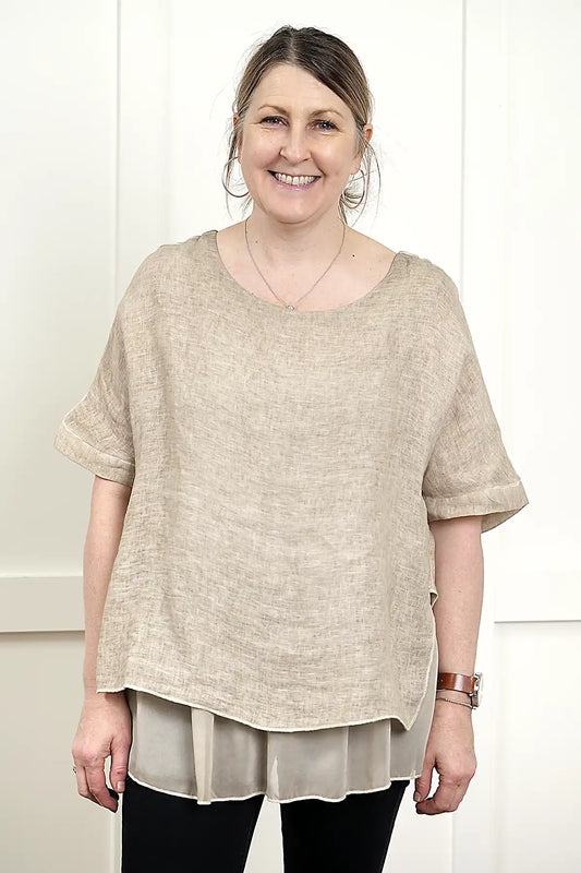 woman wearing the Elena Linen Top in Latte front view standing against a white wall