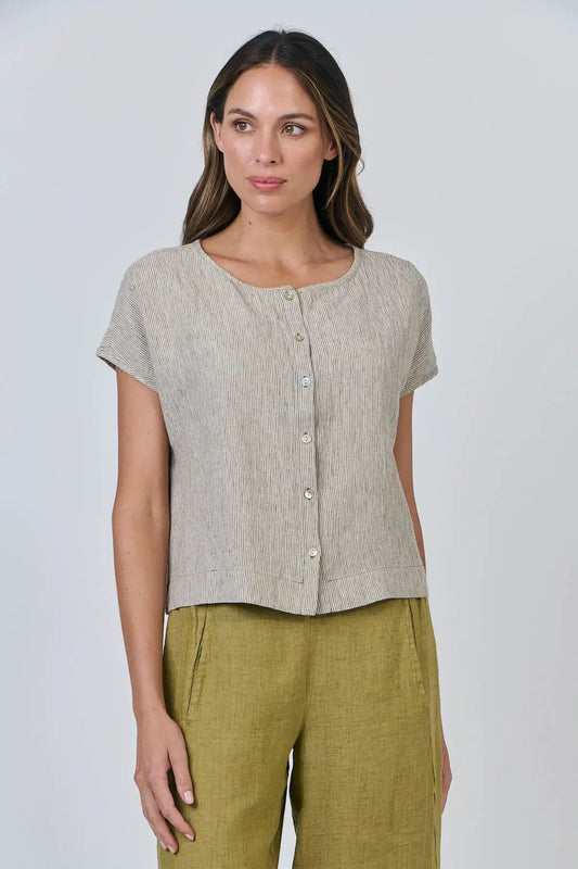 Woman wearing a Elysian Linen Top – Blister Stripe and green pants against a white background front side on view