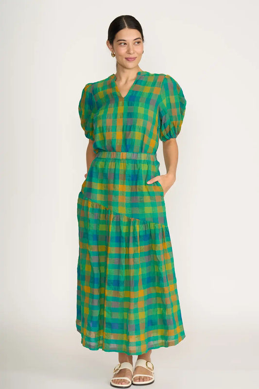 Woman wearing a Foil Checkmate Cotton Linen Skirt in Greencheck on a white background front full. model view