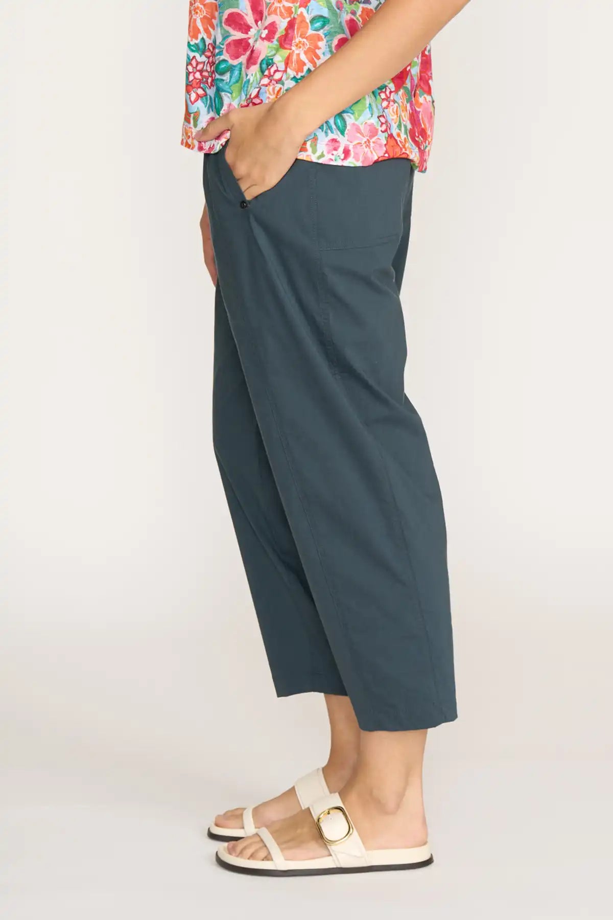 Person wearing Foil Gemini Pants in Basalt  -side view and a colorful top on a white background